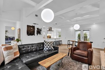 Savannah house for rent - A living room with a black leather couch and a wooden coffee table.