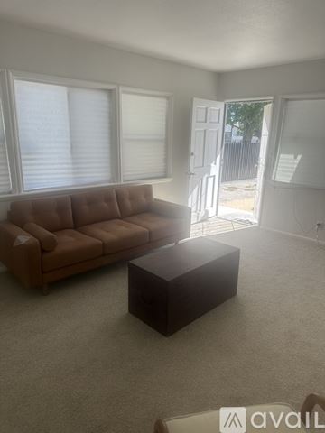 Lancaster apartment for rent - A brown couch sits in a living room with a carpeted floor and a coffee table.