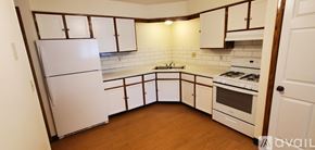 Milwaukee apartment for rent - A kitchen with white appliances and wooden floors.
