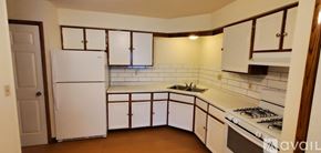 Milwaukee apartment for rent - A kitchen with white appliances and white cabinets.