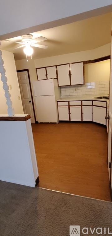 Milwaukee apartment for rent - A kitchen with white cabinets and a white fridge.