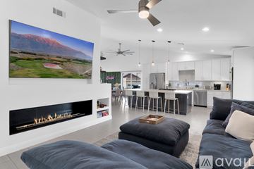 Indio house for rent - A modern living room with a large painting on the wall and a fireplace.