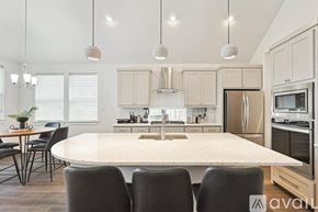 Irving house for rent - A kitchen with a table and chairs in front of it.