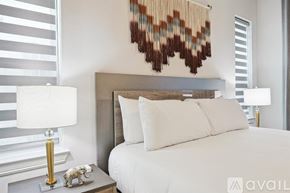 Irving house for rent - A bedroom with a white bed and a lamp on a side table.