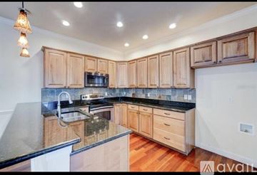Winter Park townhouse for rent - A kitchen with wooden cabinets and a black countertop.