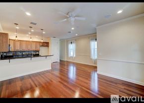 Winter Park townhouse for rent - A spacious room with wooden floors and a ceiling fan.