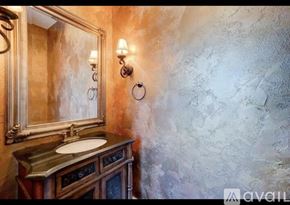 Winter Park townhouse for rent - A bathroom with a marble wall and a wooden vanity.