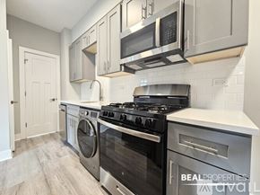 Evanston apartment for rent - A modern kitchen with a black stove top oven and a washing machine.