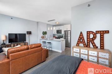 Chicago apartment for rent - A living room with a brown leather couch and a television.