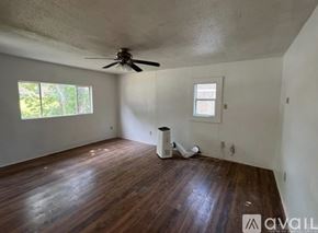 North Little Rock house for rent - A room with a ceiling fan and a window.