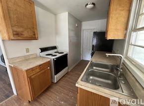 North Little Rock house for rent - A kitchen with a stove, sink, and cabinets.