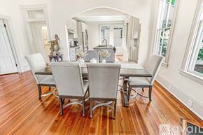 Savannah house for rent - A dining room with a wooden floor and a table set for four.