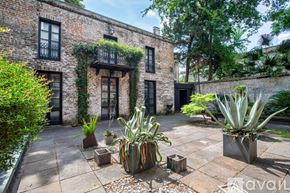 Savannah apartment for rent - A patio area with a brick building and potted plants.
