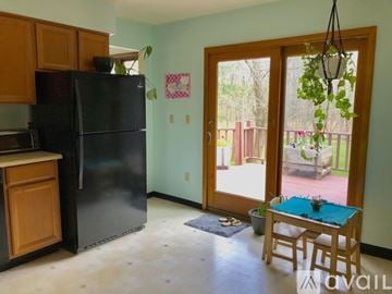 Ithaca house for rent - A kitchen with a black fridge and wooden cabinets.