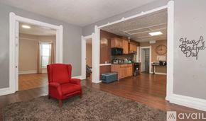 Cleveland house for rent - A red chair is in the middle of a room with a rug.