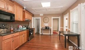 Cleveland house for rent - A kitchen with wooden cabinets and a black microwave.