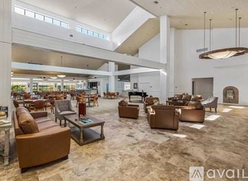 Palm Desert condo for rent - A spacious living room with brown leather furniture and a carpeted floor.