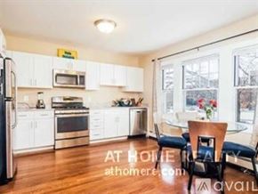 Boston apartment for rent - A kitchen with white cabinets and a refrigerator.