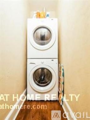 Boston apartment for rent - A white washing machine is stacked on top of another in a small space.