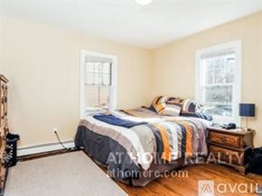 Boston apartment for rent - A bedroom with a bed, nightstand, and lamp.