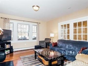 Boston apartment for rent - A living room with a black couch and a television.