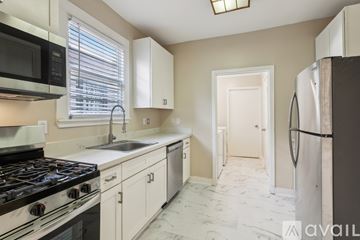 New Orleans house for rent - A kitchen with a black stove top oven and a white refrigerator.