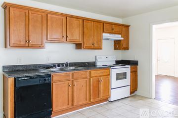 Petersburg apartment for rent - A kitchen with wooden cabinets and black appliances.