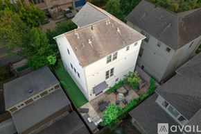 Houston house for rent - A house with a white exterior and a brown roof is surrounded by other houses.