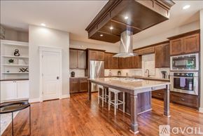 Houston house for rent - A kitchen with wooden cabinets and a center island.