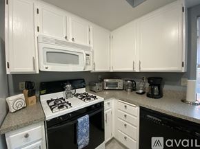 Palm Springs apartment for rent - A kitchen with white cabinets and appliances.