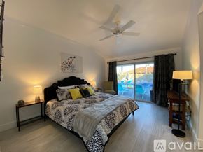Palm Springs apartment for rent - A bedroom with a large bed and a balcony overlooking a pool.