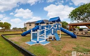 Fredericksburg apartment for rent - A playground with a blue slide and white railings.