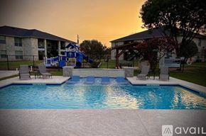 Fredericksburg apartment for rent - A pool with a slide and a building in the background.
