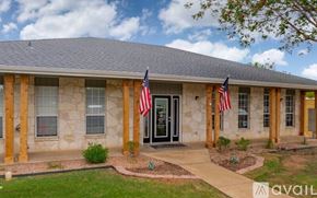 Fredericksburg apartment for rent - A house with a stone facade and two American flags on either side of the entrance.