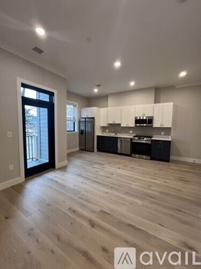 Boston apartment for rent - A spacious kitchen with wooden flooring and white cabinets.