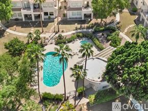 Scottsdale condo for rent - A pool surrounded by trees and a building in the background.