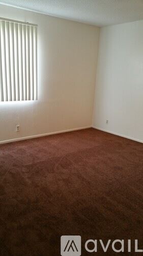 Bakersfield apartment for rent - A room with a wooden floor and a window with blinds.