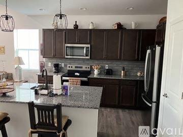 Hardeeville house for rent - A kitchen with brown cabinets and a granite countertop.