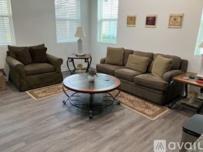 Hardeeville house for rent - A living room with a brown couch, a chair, and a coffee table.