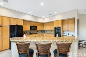 La Quinta house for rent - A kitchen with wooden cabinets and granite countertops.