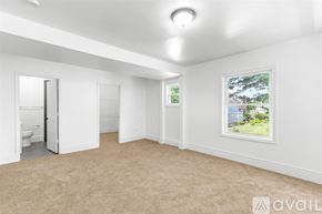 Detroit house for rent - A room with a carpeted floor and a window showing a tree and a house outside.