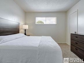 Austin apartment for rent - A bedroom with a bed, dresser, and window.
