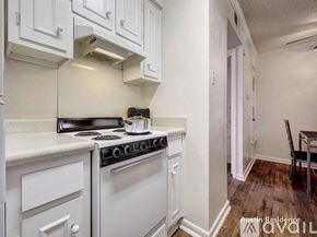Austin apartment for rent - A white kitchen with a stove top oven and a white cabinet.