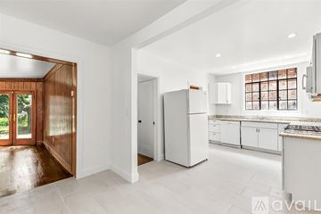 Detroit house for rent - A kitchen with white cabinets and a white fridge.
