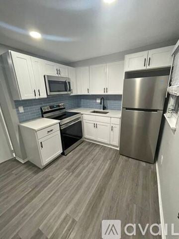 Blackwood apartment for rent - A kitchen with a stove top oven, microwave, refrigerator, and sink.