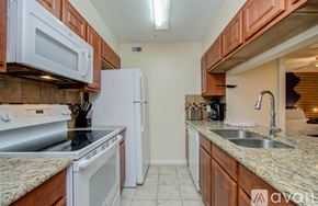 Houston apartment for rent - A kitchen with brown cabinets and white appliances.
