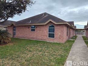 Edinburg apartment for rent - A brick house with a dark roof and a small front yard.