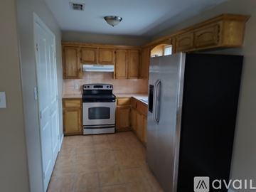 Edinburg apartment for rent - A kitchen with wooden cabinets and a black refrigerator.
