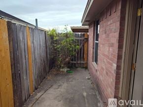 Edinburg apartment for rent - A backyard with a wooden fence and a brick building.