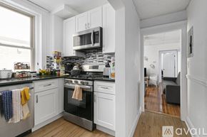 Cambridge apartment for rent - A kitchen with white cabinets and a black stove top oven.